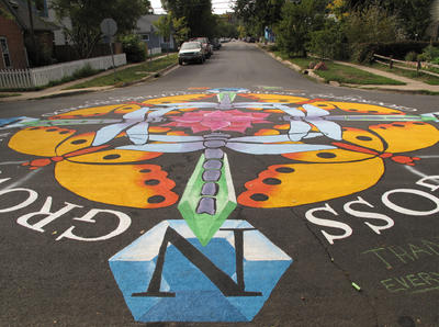 Goss-Grove neighborhood in Boulder, Colorado — colorful hand-painted street mural with a butterfly and the neighborhood name across an intersection