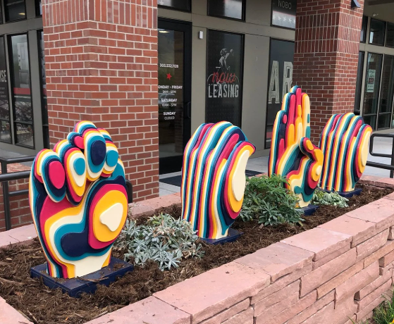NoBo Art District in North Boulder, Colorado — colorful multicolored sculptural hands as public art outside mixed-use storefronts in the city's creative arts hub