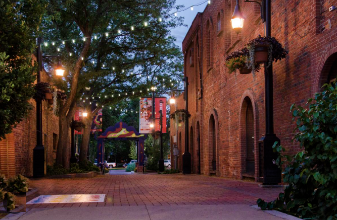 Old Town Longmont — historic brick alley with string lights and tree canopy